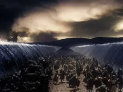 Crowd walking on dry land between two towering walls of parted sea under dramatic sky.